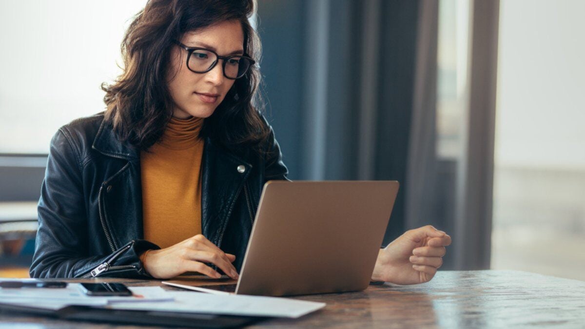 A woman using a laptop looking focused